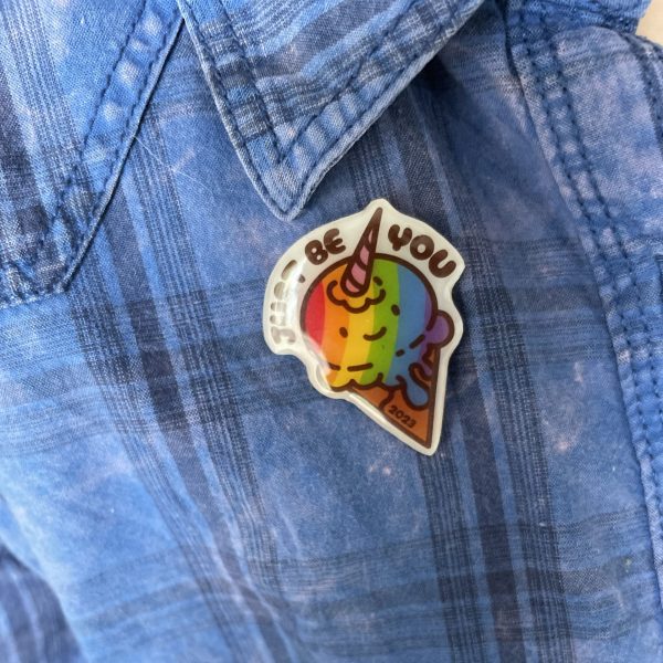 Just Be You rainbow ice cream Pride badge on a pink and blue denim shirt with a plaid pattern